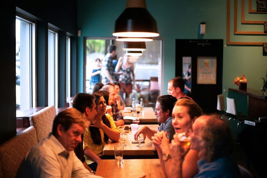 people sitting beside brown wooden table inside room